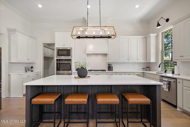 6603 Wirtz Rd, Flowood, MS 39232 - kitchen with stainless steel appliances, backsplash, a kitchen island, white cabinets, and light wood-style floors