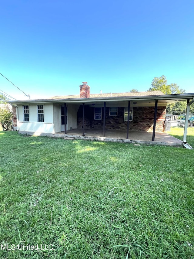 8301 Concord Cv, Southaven, MS 38671 - back of house featuring a chimney, a yard, and a patio area