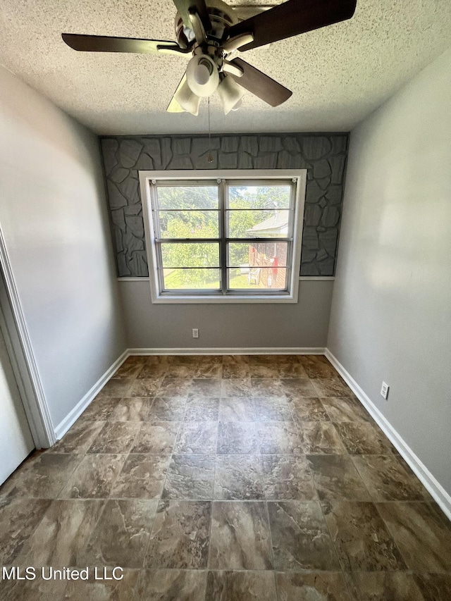 8301 Concord Cv, Southaven, MS 38671 - empty room featuring baseboards, stone finish floor, a ceiling fan, and a textured ceiling