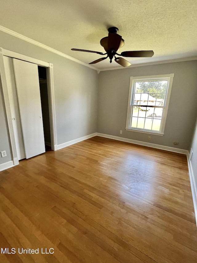8301 Concord Cv, Southaven, MS 38671 - unfurnished bedroom featuring baseboards, ornamental molding, a textured ceiling, and wood finished floors