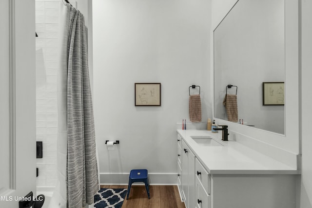 bathroom featuring vanity, baseboards, and wood finished floors