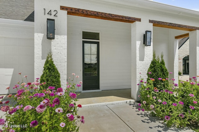 entrance to property with brick siding and a porch