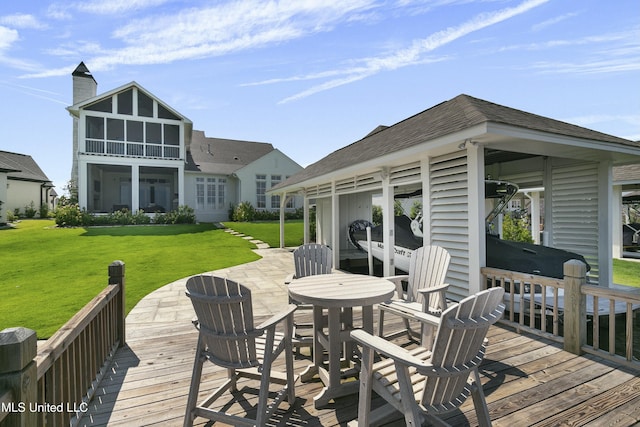 wooden deck with a lawn, a patio area, and a sunroom