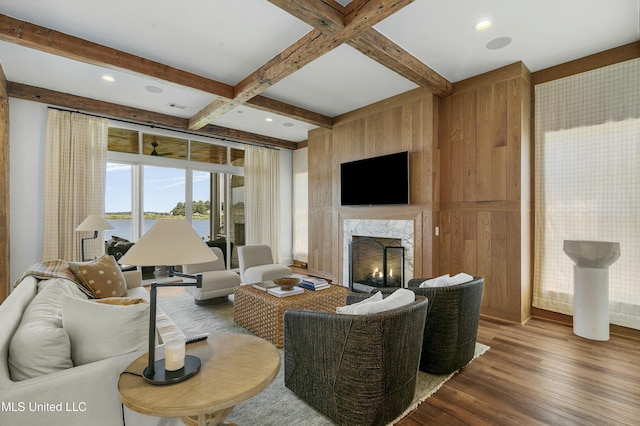 living room with coffered ceiling, wood finished floors, visible vents, a high end fireplace, and beam ceiling