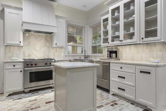 6416 Oliwa Pl, Diamondhead, MS 39525 - kitchen with stainless steel appliances, brick flooring, light stone countertops, white cabinetry, and crown molding