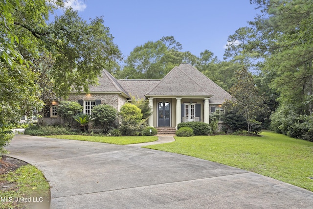 6416 Oliwa Pl, Diamondhead, MS 39525 - view of front of property featuring a front yard, a shingled roof, brick siding, and driveway