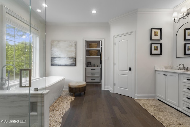 6416 Oliwa Pl, Diamondhead, MS 39525 - bathroom with vanity, a freestanding tub, wood finished floors, recessed lighting, and ornamental molding