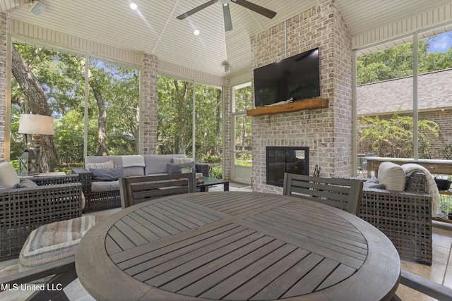 6416 Oliwa Pl, Diamondhead, MS 39525 - sunroom with outdoor dining area, ceiling fan, an outdoor living space with a fireplace, and plenty of natural light