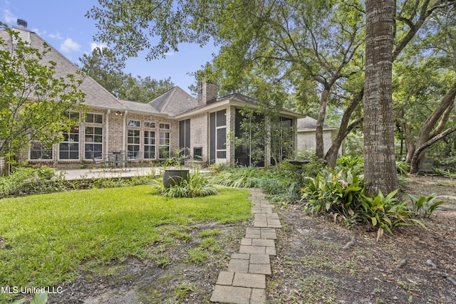 6416 Oliwa Pl, Diamondhead, MS 39525 - back of property featuring a chimney, a patio area, brick siding, a yard, and roof with shingles