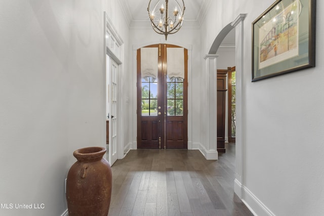 6416 Oliwa Pl, Diamondhead, MS 39525 - entrance foyer featuring arched walkways, a chandelier, ornamental molding, and dark wood-type flooring