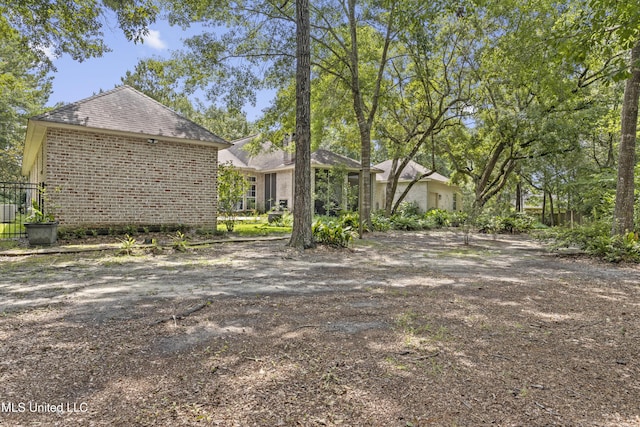 6416 Oliwa Pl, Diamondhead, MS 39525 - rear view of property featuring brick siding and a shingled roof