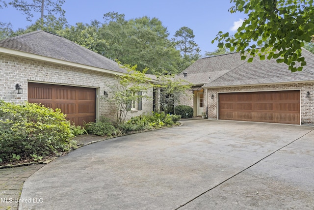 6416 Oliwa Pl, Diamondhead, MS 39525 - view of front facade featuring a garage, brick siding, concrete driveway, and a shingled roof