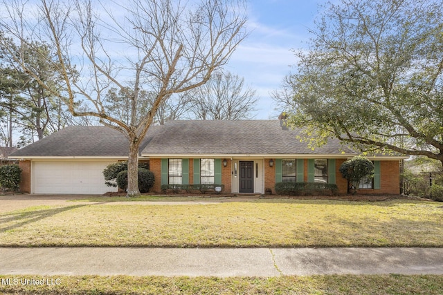 single story home featuring a garage, a front lawn, and brick siding