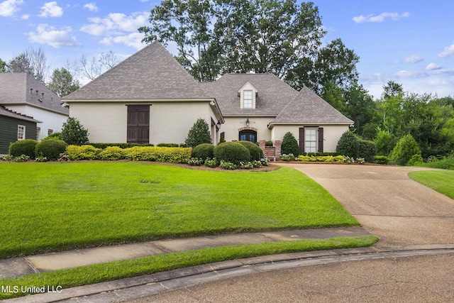 french provincial home with a front yard