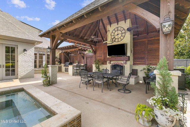 view of patio / terrace with a gazebo, an outdoor kitchen, exterior bar, and ceiling fan