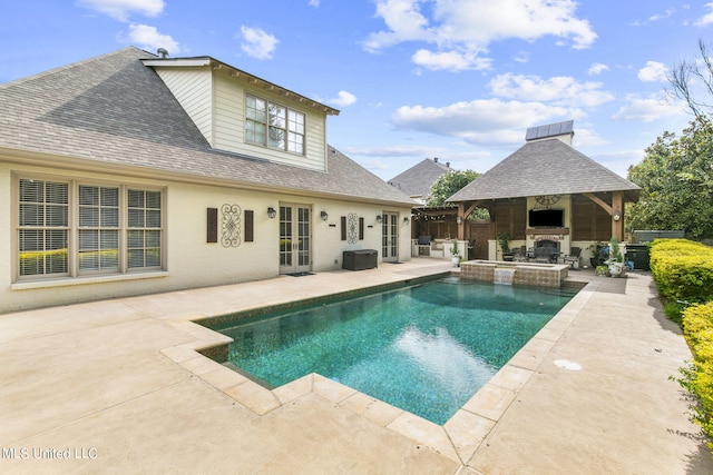 view of swimming pool with a patio and a fireplace