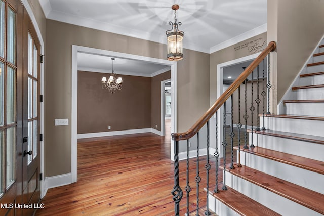 foyer featuring hardwood / wood-style floors, a notable chandelier, and crown molding