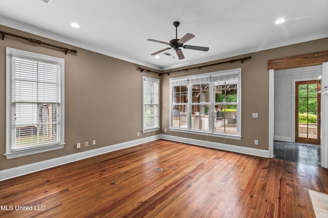 spare room featuring wood-type flooring and plenty of natural light