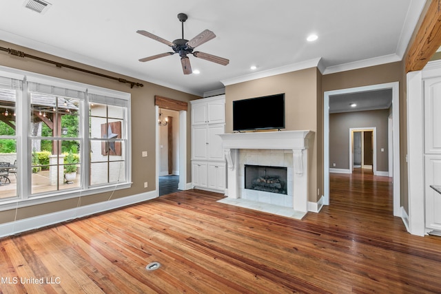 unfurnished living room featuring crown molding, a fireplace, wood-type flooring, and ceiling fan