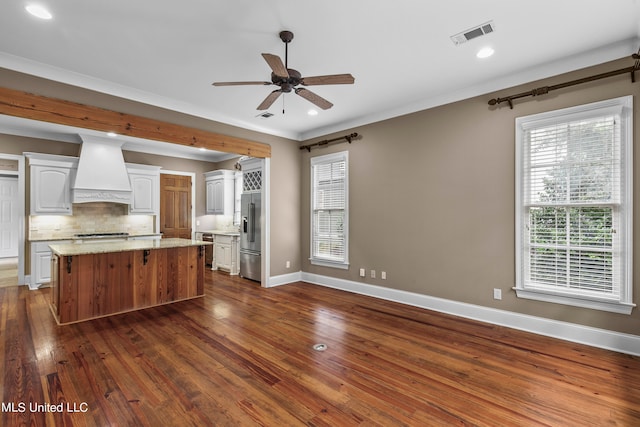 kitchen with crown molding, premium range hood, dark hardwood / wood-style floors, and white cabinets