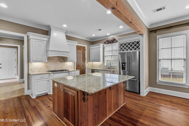 kitchen featuring a kitchen island, white cabinetry, stainless steel appliances, premium range hood, and dark hardwood / wood-style floors