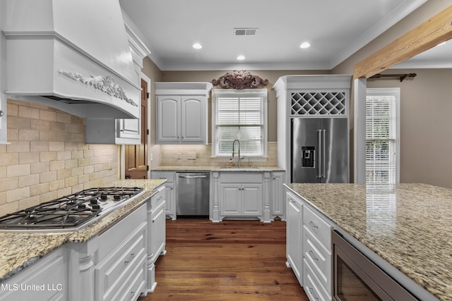 kitchen with dark wood-type flooring, appliances with stainless steel finishes, white cabinetry, and plenty of natural light