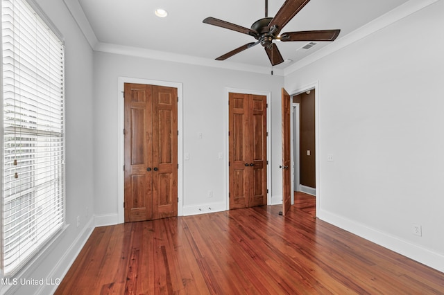 unfurnished bedroom with crown molding, hardwood / wood-style floors, and ceiling fan