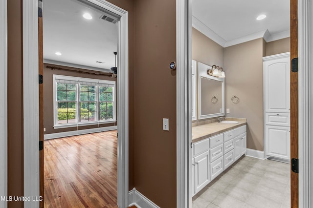 bathroom with vanity, ornamental molding, and wood-type flooring