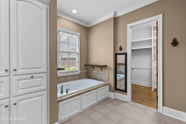 bathroom featuring a tub to relax in, ornamental molding, and hardwood / wood-style floors