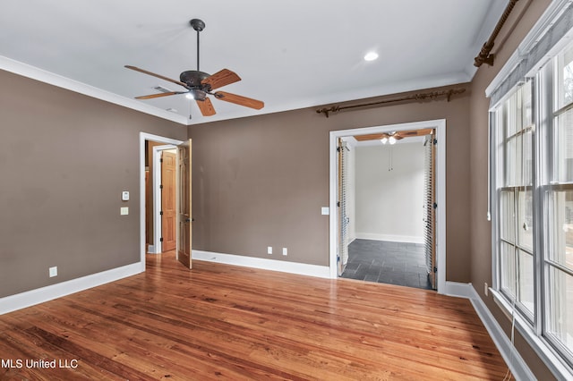 empty room featuring ornamental molding, hardwood / wood-style flooring, and ceiling fan