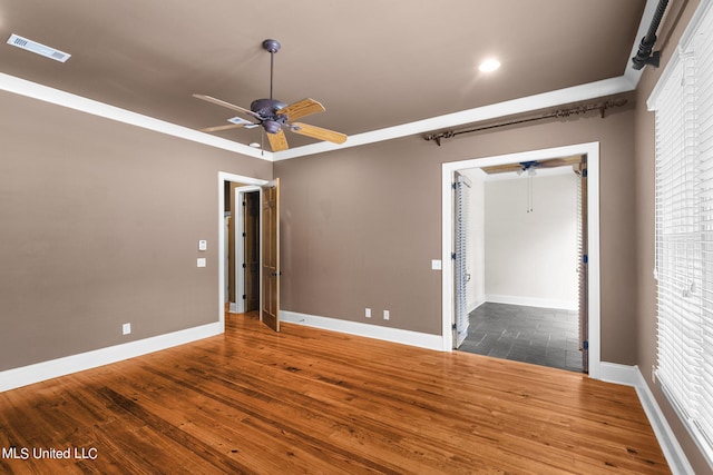 unfurnished bedroom with a closet, crown molding, wood-type flooring, and ceiling fan