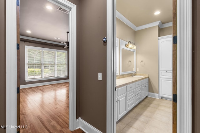 bathroom with vanity, crown molding, wood-type flooring, and ceiling fan