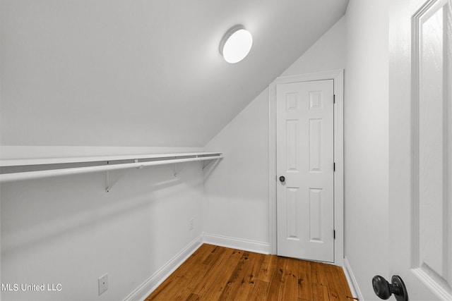 spacious closet with vaulted ceiling and hardwood / wood-style flooring