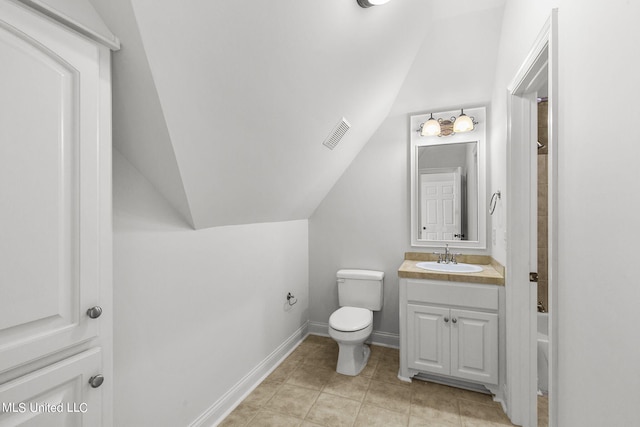 bathroom with vanity, vaulted ceiling, toilet, and tile patterned flooring