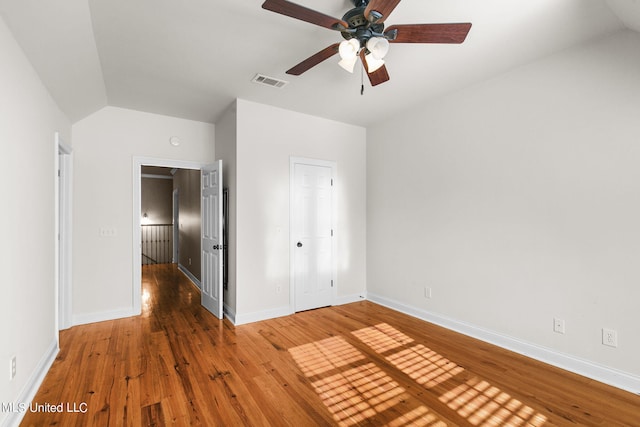 unfurnished bedroom with a closet, ceiling fan, hardwood / wood-style flooring, and lofted ceiling