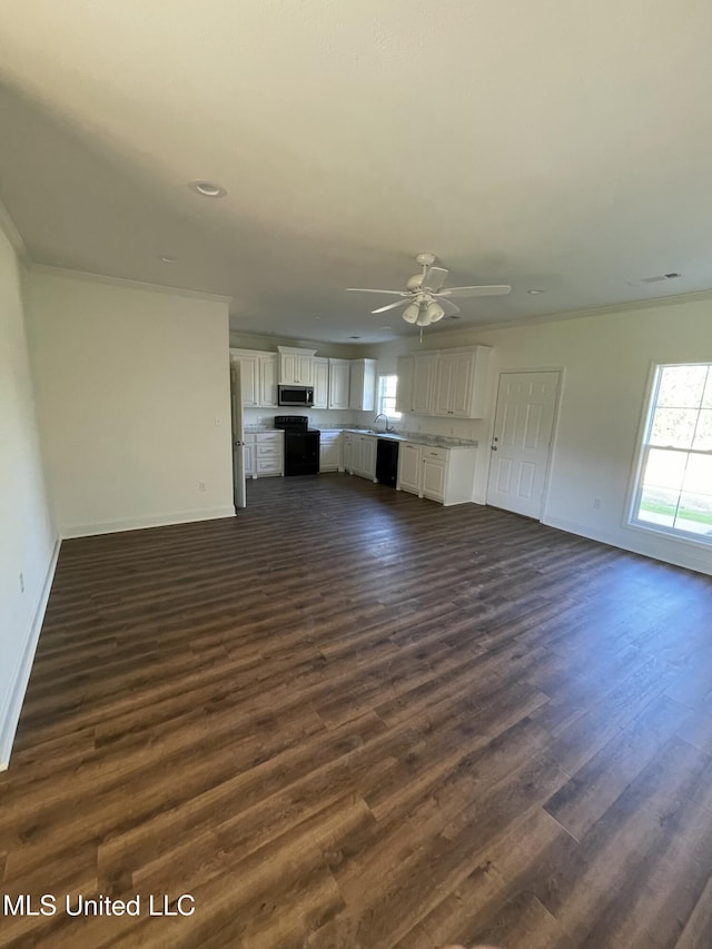 unfurnished living room featuring dark wood-style floors, baseboards, and crown molding