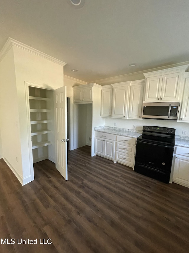 kitchen featuring black electric range, crown molding, dark wood finished floors, stainless steel microwave, and white cabinetry