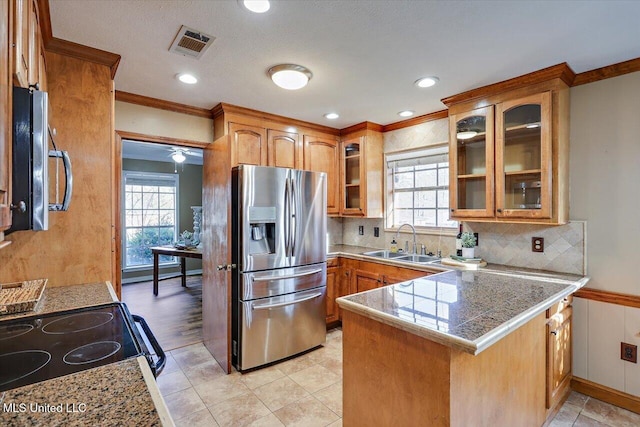 kitchen with brown cabinets, visible vents, a sink, a peninsula, and stainless steel fridge with ice dispenser