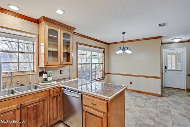 kitchen featuring brown cabinets, visible vents, a sink, dishwasher, and a peninsula