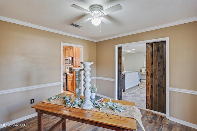 home office featuring a ceiling fan, wood finished floors, visible vents, and baseboards