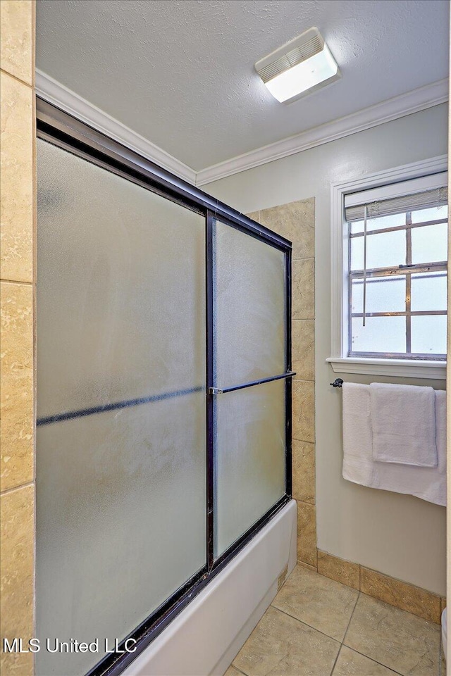 bathroom featuring bath / shower combo with glass door, visible vents, ornamental molding, a textured ceiling, and tile patterned floors