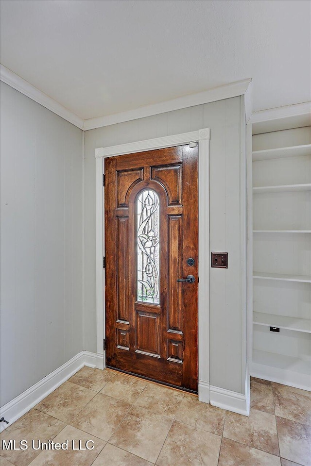 entrance foyer with baseboards and crown molding