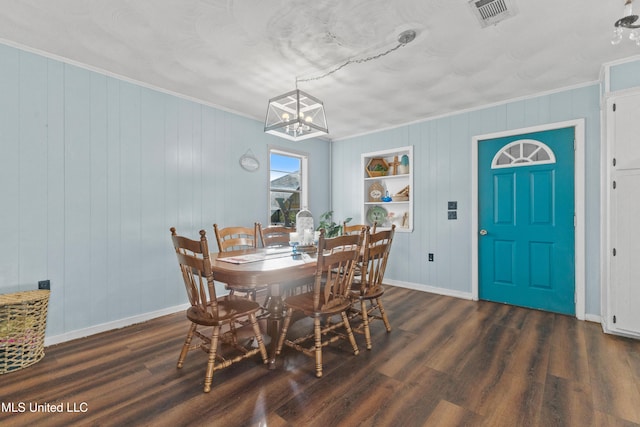 dining space featuring dark hardwood / wood-style floors, wood walls, and ornamental molding