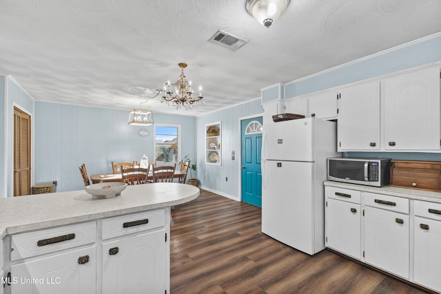 kitchen featuring white cabinets, white refrigerator, hanging light fixtures, and dark wood-type flooring