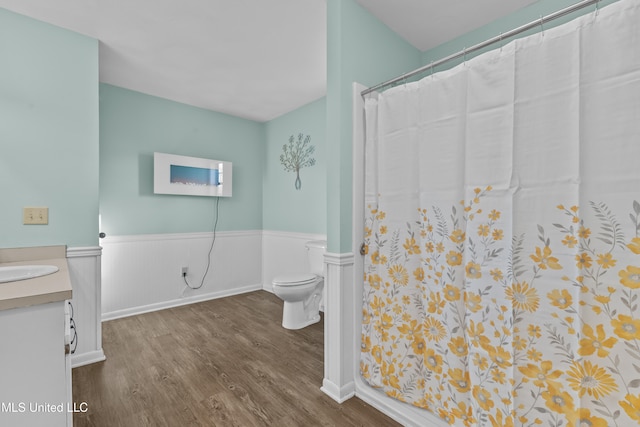 bathroom with hardwood / wood-style floors, vanity, toilet, and a shower with curtain