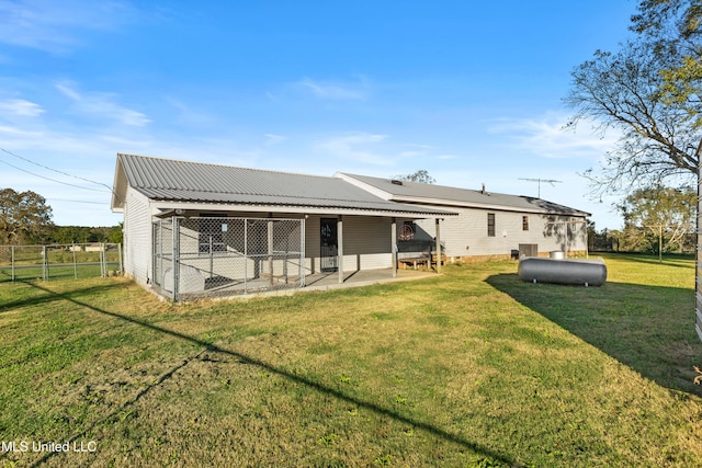 rear view of house featuring a lawn and a patio