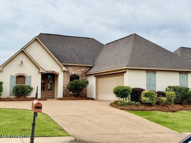 508 Springhill Xing, Brandon, MS 39047 - french country inspired facade with driveway, roof with shingles, a garage, french doors, and a front yard