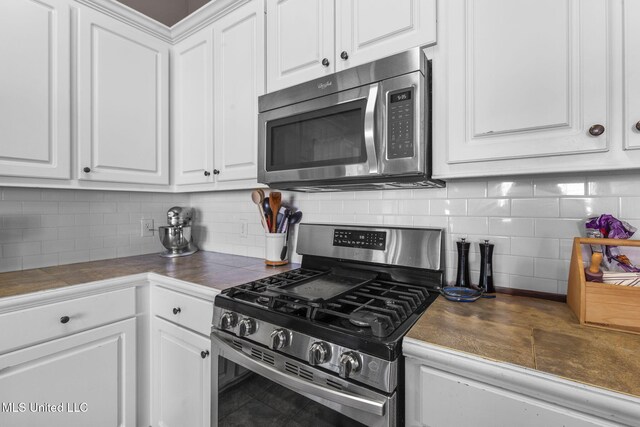 169 Beechwood Cir, Pearl, MS 39208 - kitchen featuring appliances with stainless steel finishes, white cabinetry, and decorative backsplash