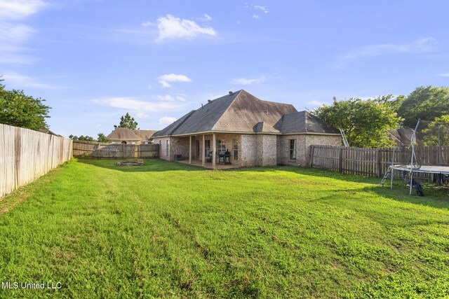 169 Beechwood Cir, Pearl, MS 39208 - back of house with a trampoline, a patio, and brick siding