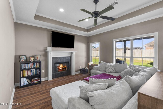 169 Beechwood Cir, Pearl, MS 39208 - living room with dark wood-style flooring, a tray ceiling, crown molding, ceiling fan, and a tile fireplace